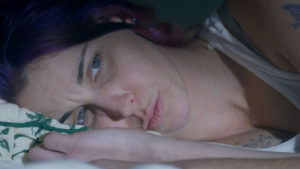 Woman with purple hair in bed closeup